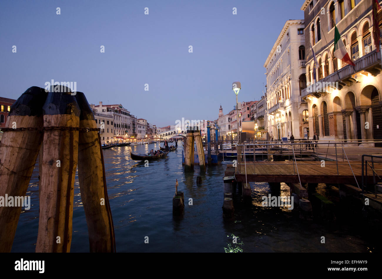 Vista al tramonto da un acqua taxi jetty che mostra il Canal Grande con il ponte di Rialto in background in Venezia, Italia Foto Stock
