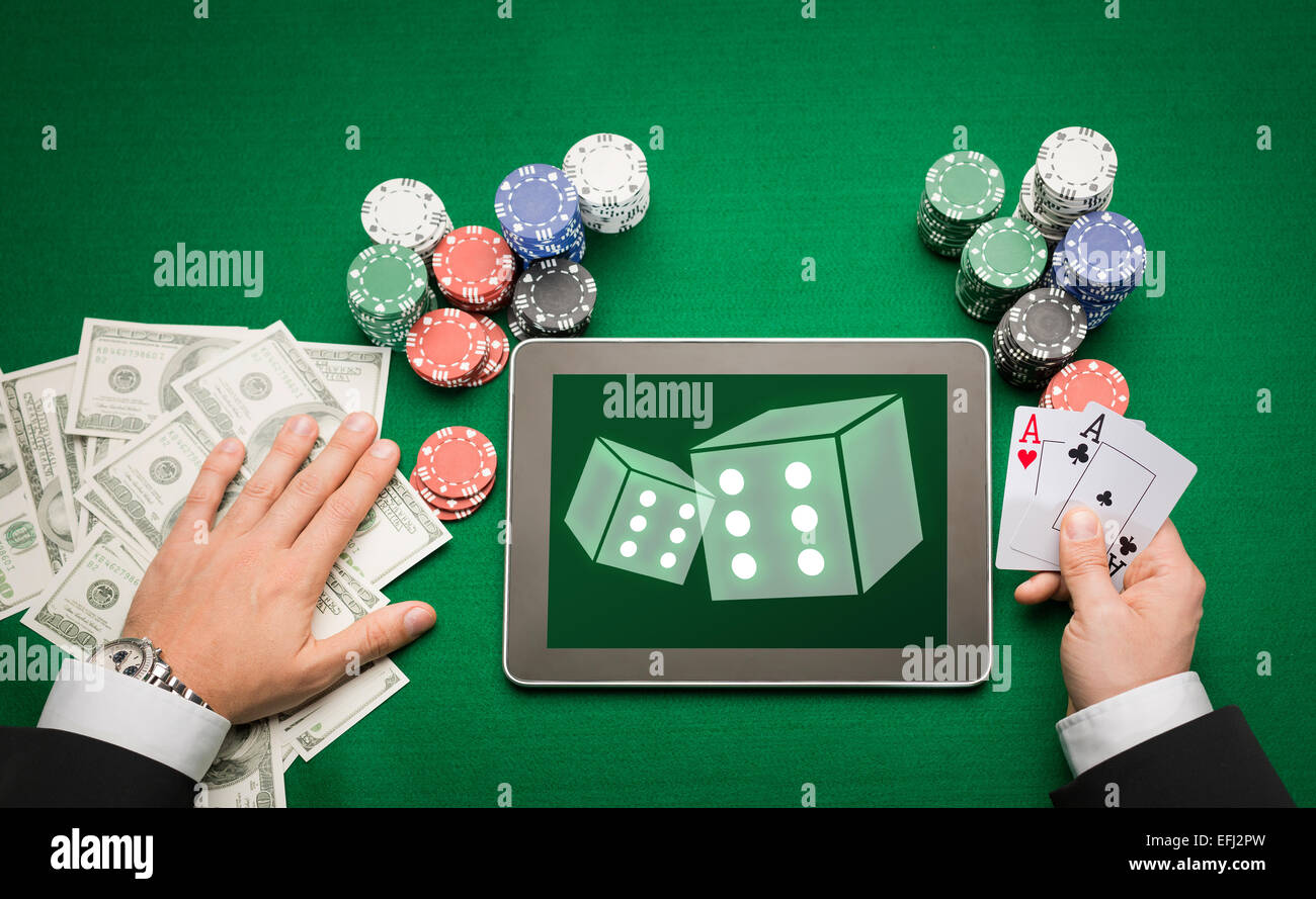 Casinò poker player con cards, tablet e trucioli Foto Stock