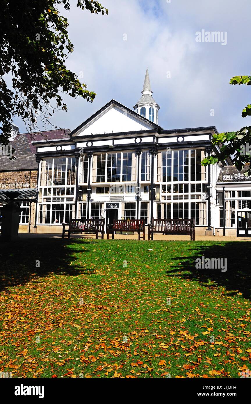 Gli edifici in stile vittoriano nel Pavilion Gardens con foglie di autunno in primo piano, Buxton, Derbyshire, England, Regno Unito, Europa. Foto Stock