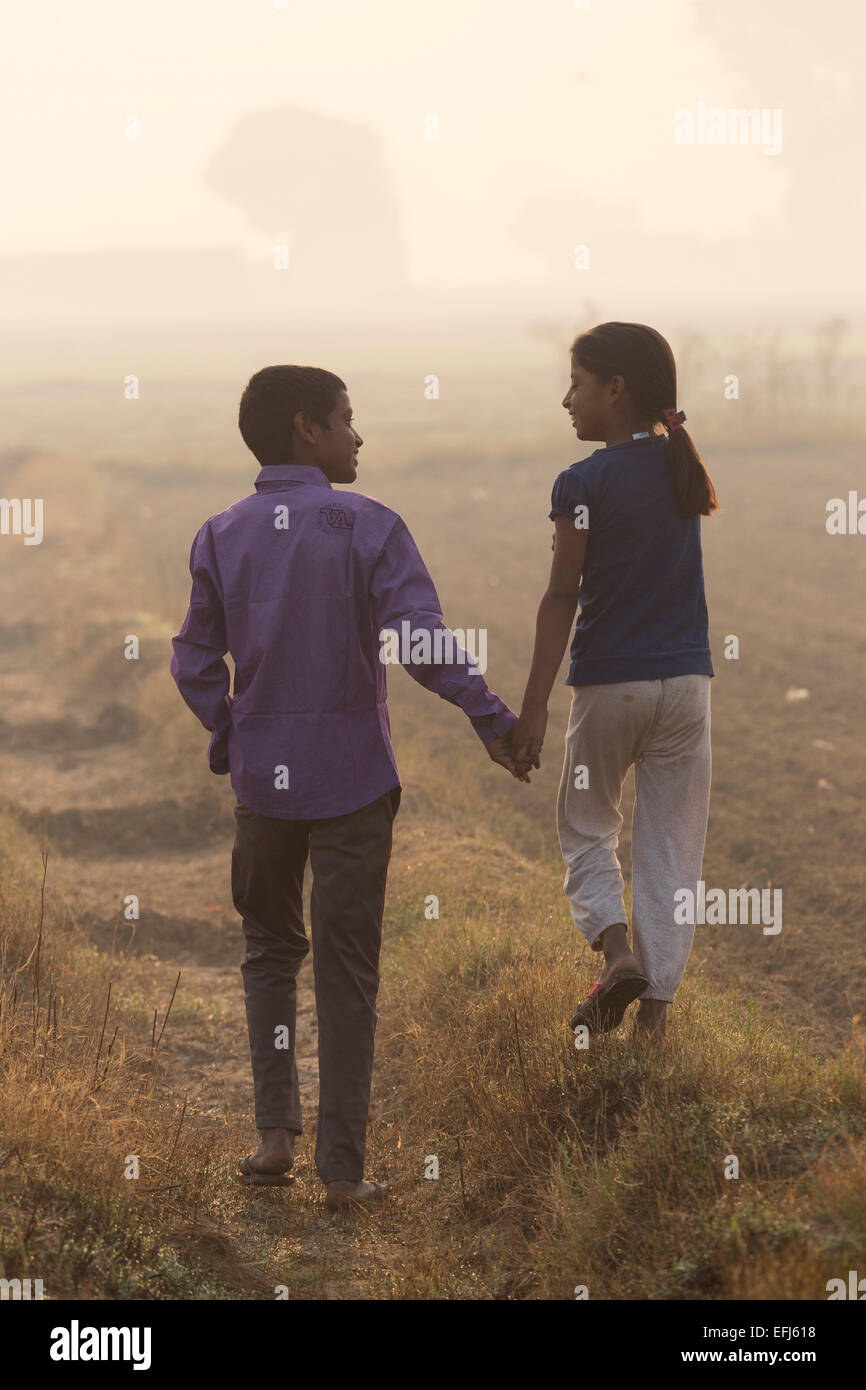 India, Uttar Pradesh, Agra, fratello e sorella e tenendo le mani a piedi nel campo Foto Stock