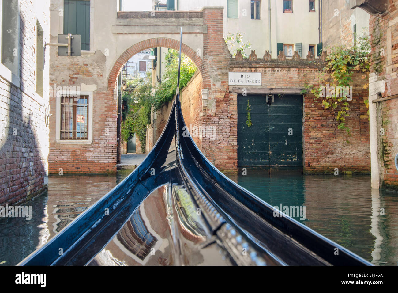 Gondola Veneziana lungo i canali laterali,preso dalla gondola per includere riflessioni. Foto Stock
