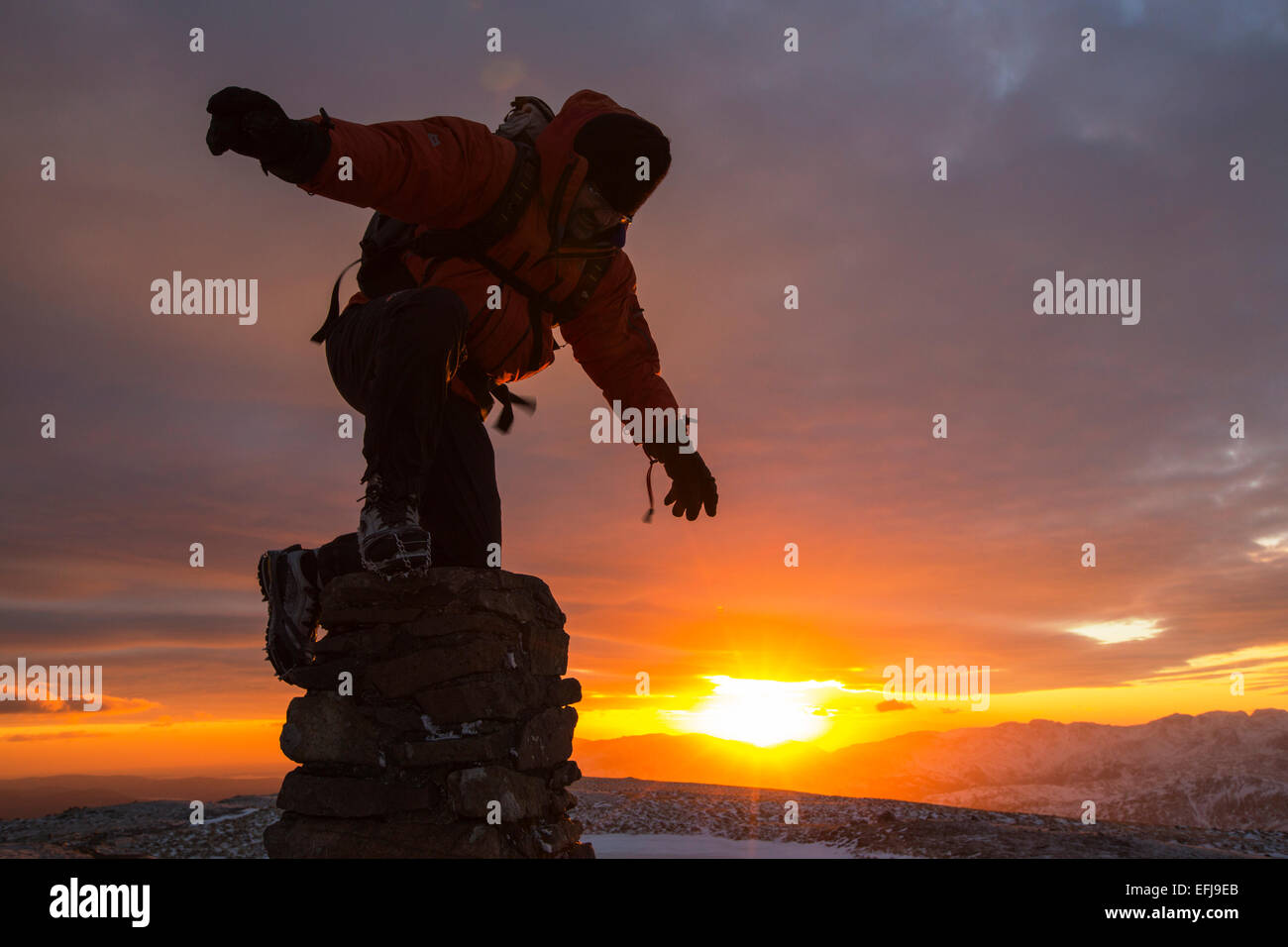 Un viandante sul vertice di Rosso ghiaioni al tramonto nel distretto del lago, UK, prese su Mercoledì 4 febbraio 2015 Foto Stock