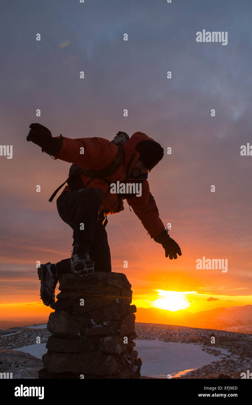 Un viandante sul vertice di Rosso ghiaioni al tramonto nel distretto del lago, UK, prese su Mercoledì 4 febbraio 2015 Foto Stock