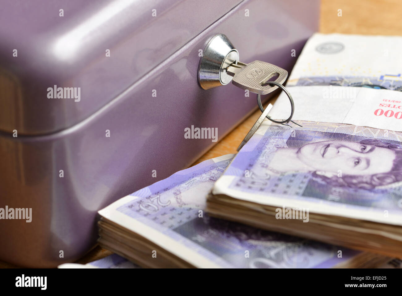 Cassa con pile di venti pound note Foto Stock