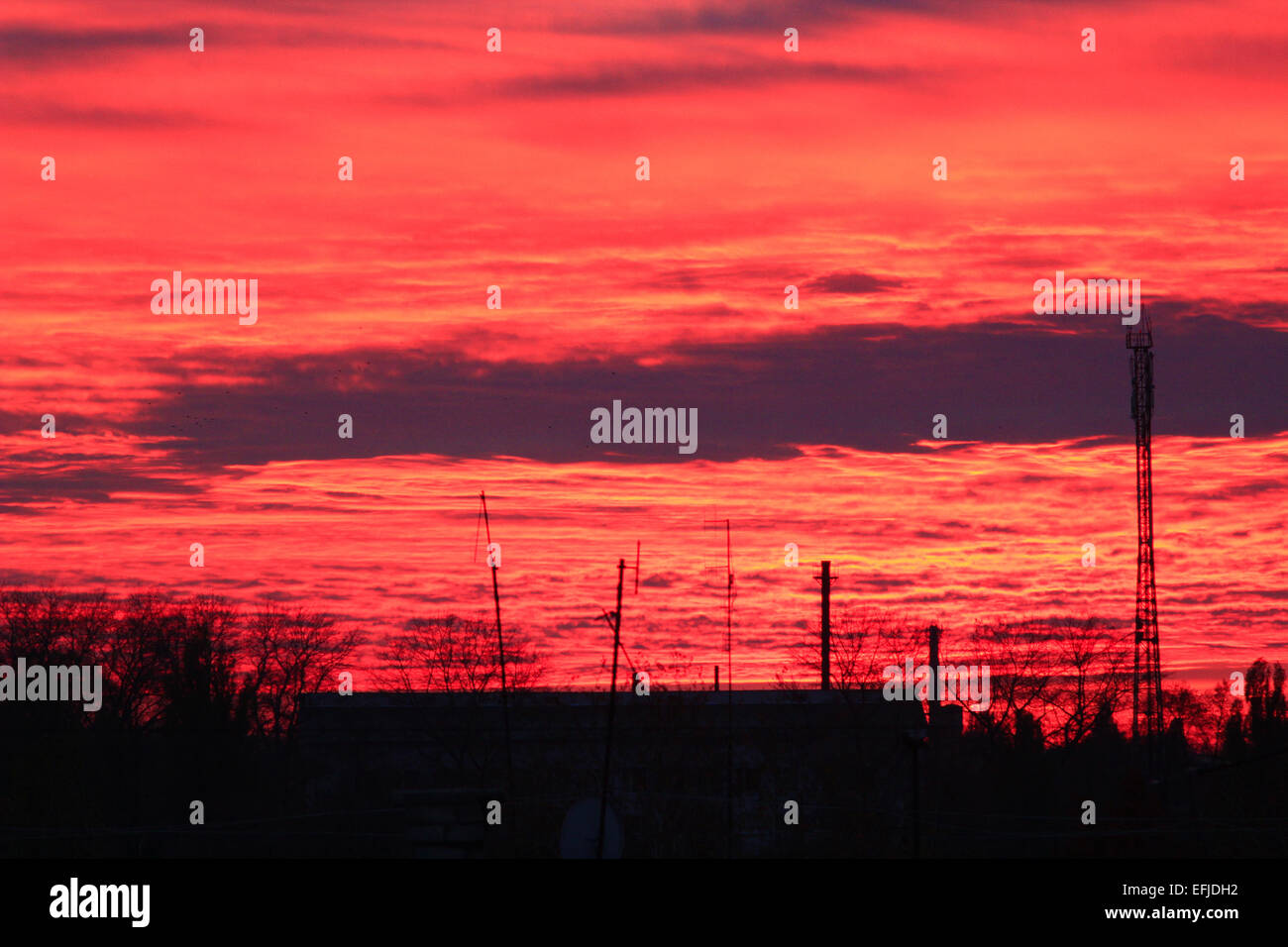 La sera al tramonto scarlatto con splendido e pittoresco nuvole sopra le case Foto Stock