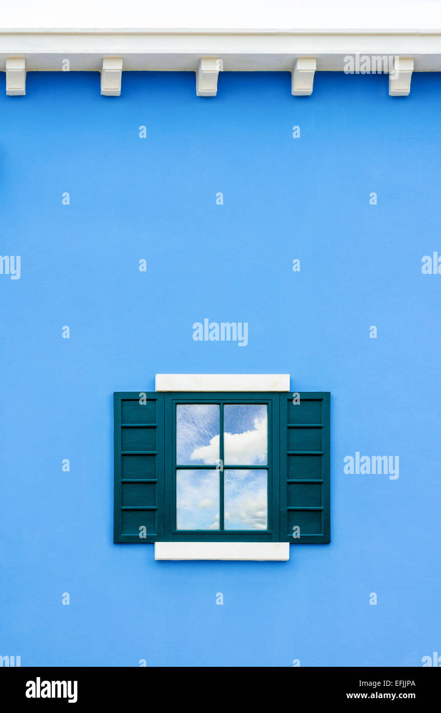 Sky e cloud riflessione nella finestra verde vetro blu sulla parete della casa, Italia uno stile rétro Foto Stock