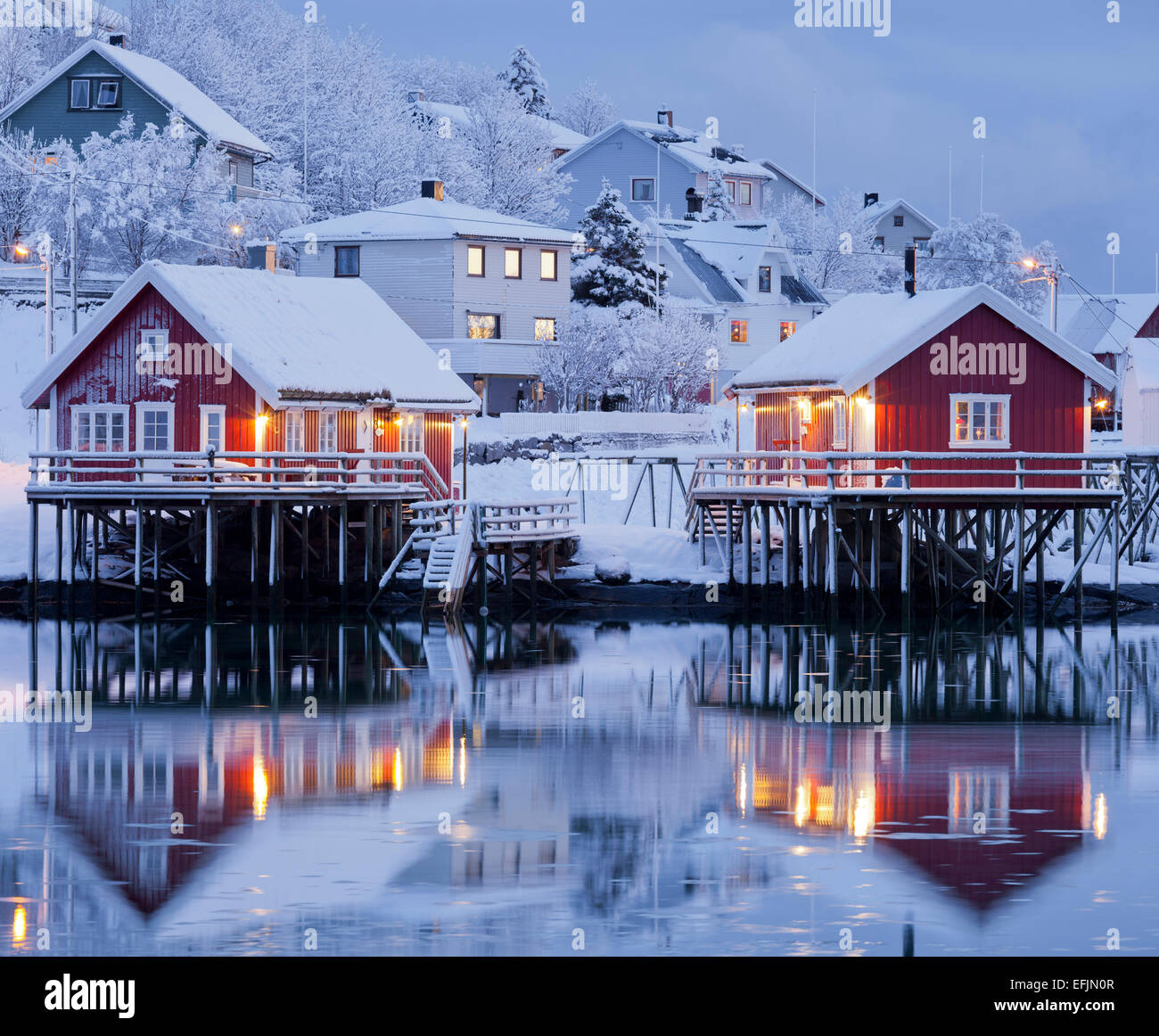 Reine nella luce della sera, riflesso nell'acqua, la Reine, Moskenesoya, Lofoten, Nordland, Norvegia Foto Stock
