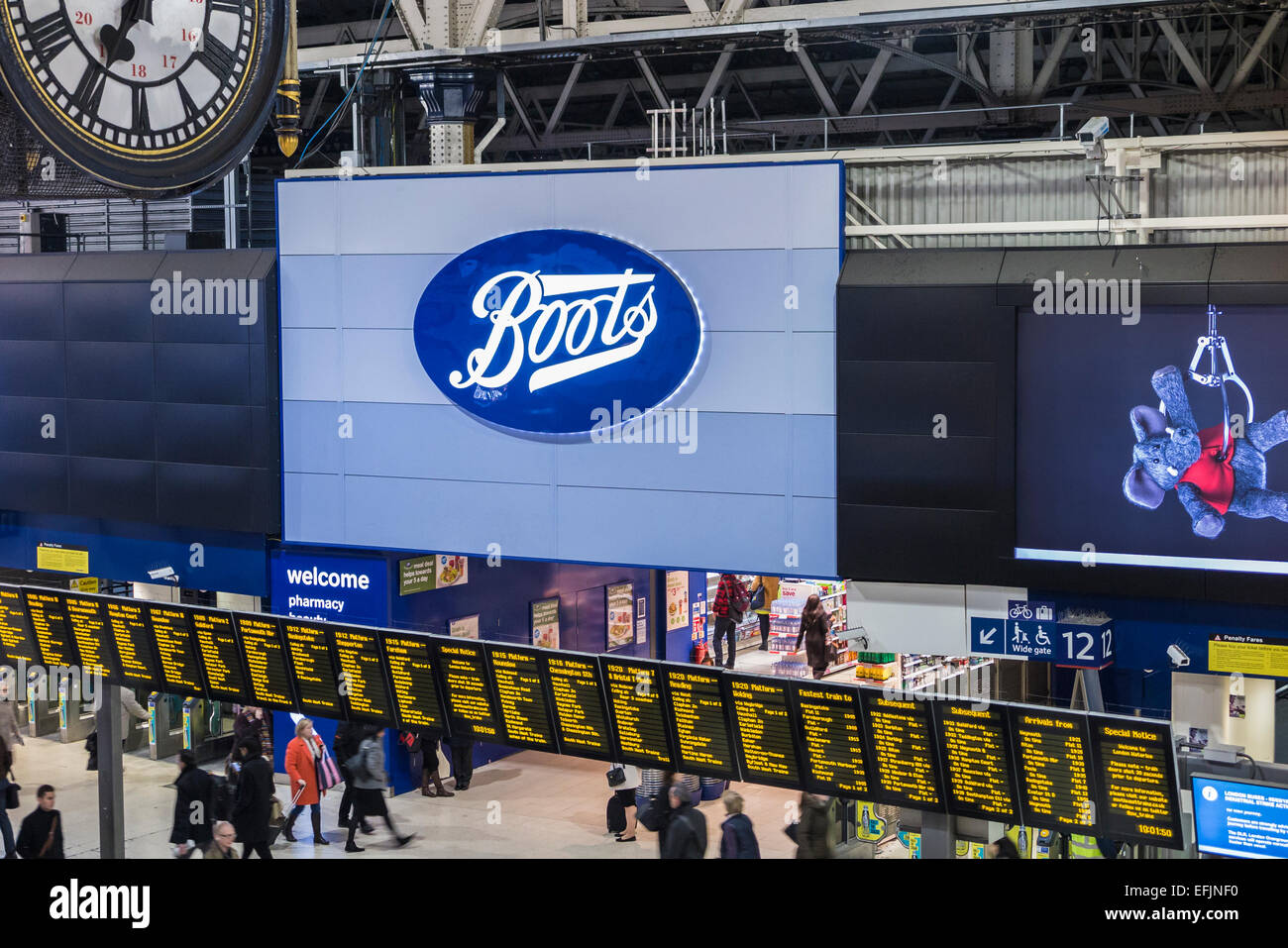 Stivali shop segno e logo alla Stazione Waterloo di Londra dirigersi al di sopra delle schede di partenza, con inizio serata pendolari Foto Stock