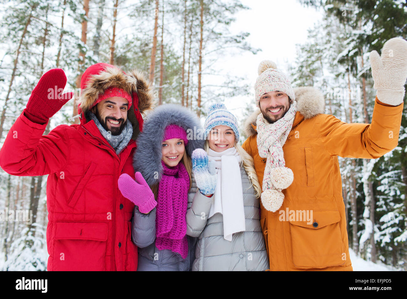 Gruppo di amici sventolando le mani nella foresta di inverno Foto Stock