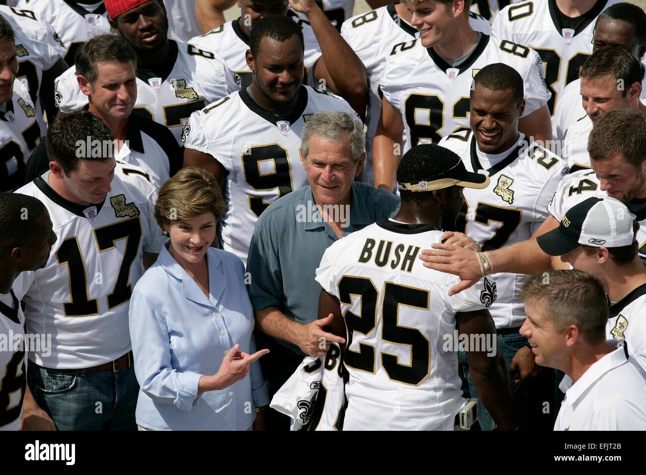 Il presidente americano George Bush e la First Lady Laura Bush sono circondati dai membri dei New Orleans Saints football team ricorda il nome dei Santi star rookie running back Reggie Bush Agosto 29, 2006 a New Orleans, Louisiana. Foto Stock