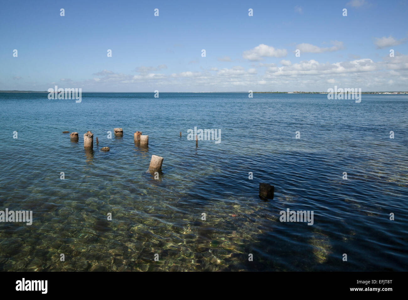 Vecchi tralicci nelle limpide acque blu della Baia di Cienfuegos, Punta Gorda, Cienfuegos, Cuba. Foto Stock