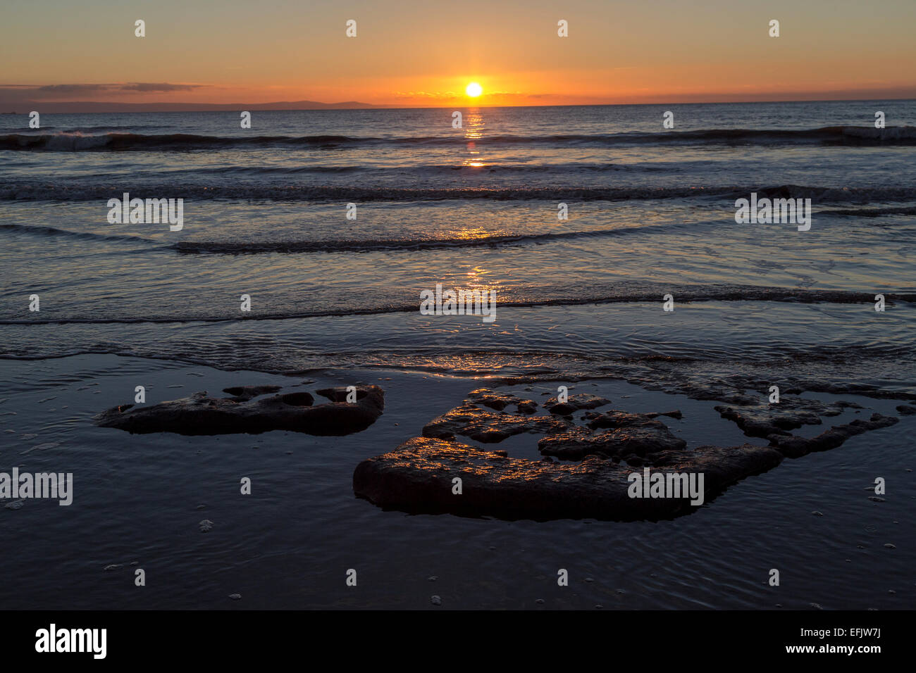 Tramonto sul mare calmo a Southerndown, Wales, Regno Unito Foto Stock