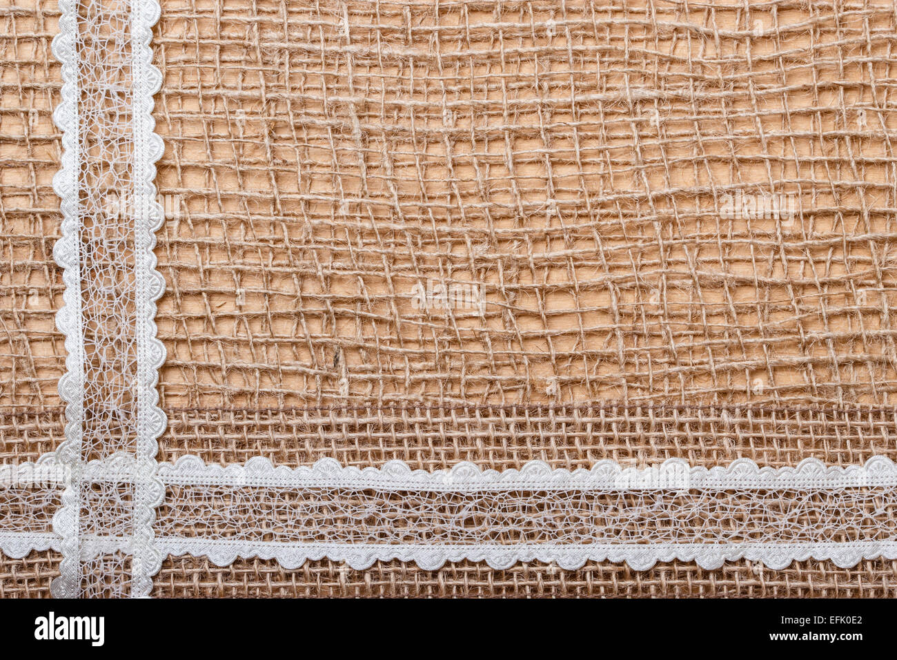 Pizzi e Merletti in sacchi di iuta di nastro sulla maglia marrone materiale, naturale sfondo di tela Foto Stock