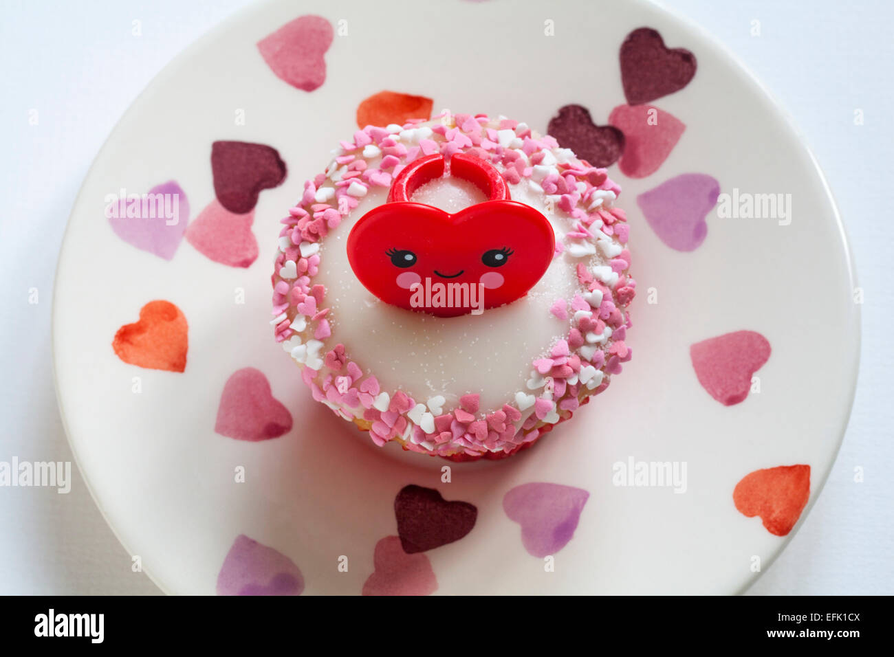 Valentino anello rosso cupcake impostato sulla piastra di cuore su sfondo bianco - ideale per il giorno di San Valentino, il giorno di san valentino Foto Stock