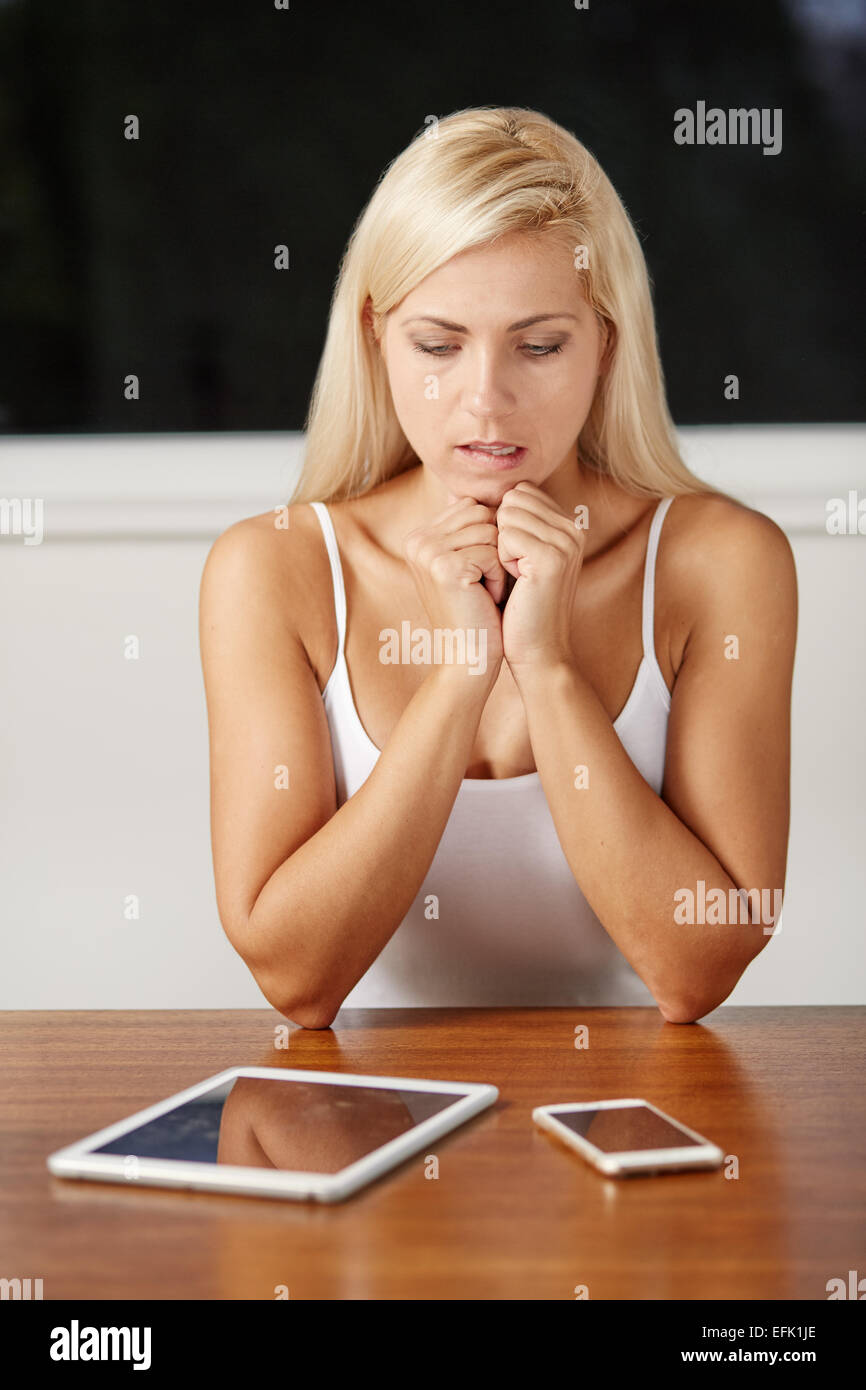 Sottolineato ragazza utilizzando iPad e dispositivi mobili Foto Stock