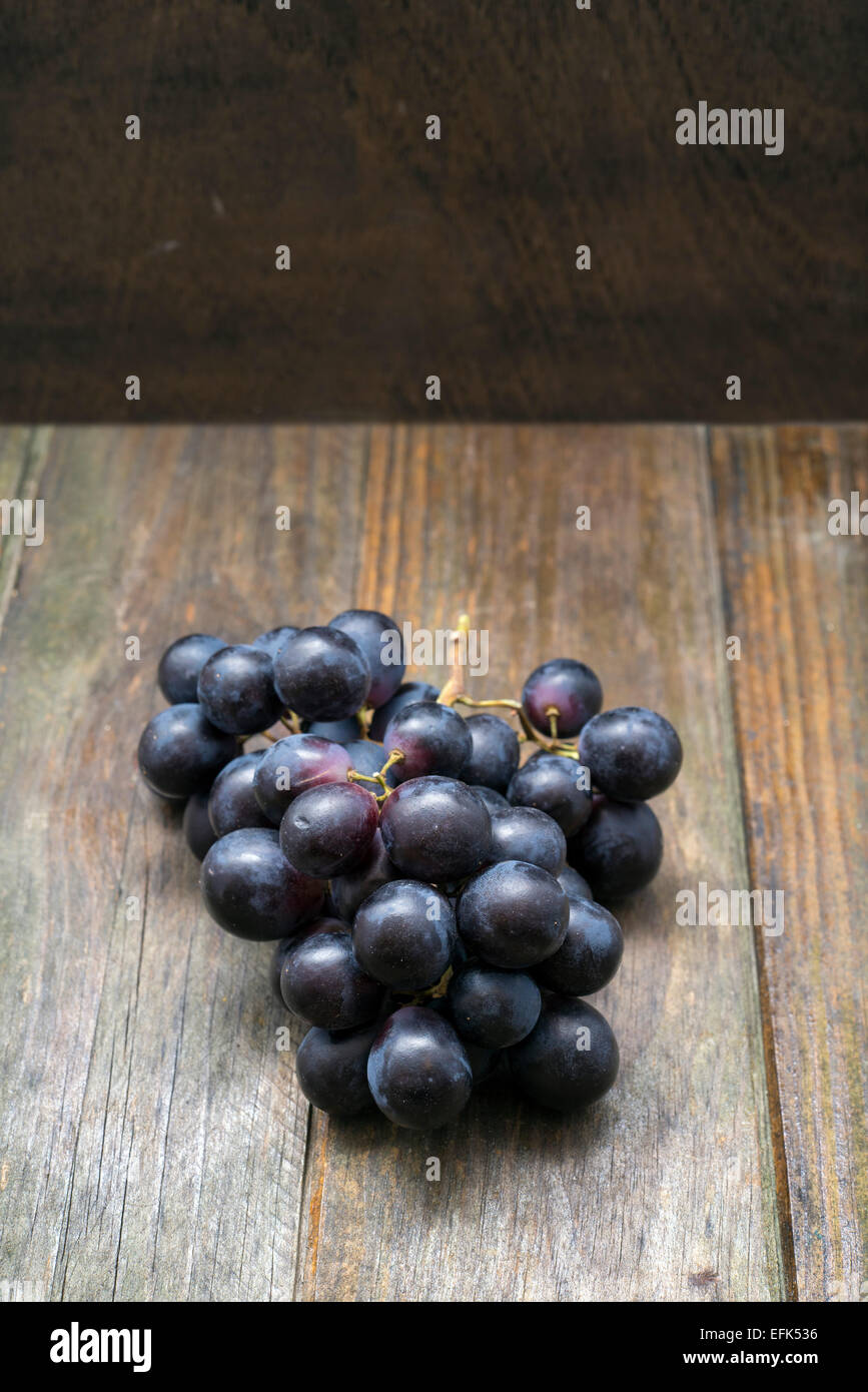 Grappolo di uva su una superficie di legno Foto Stock