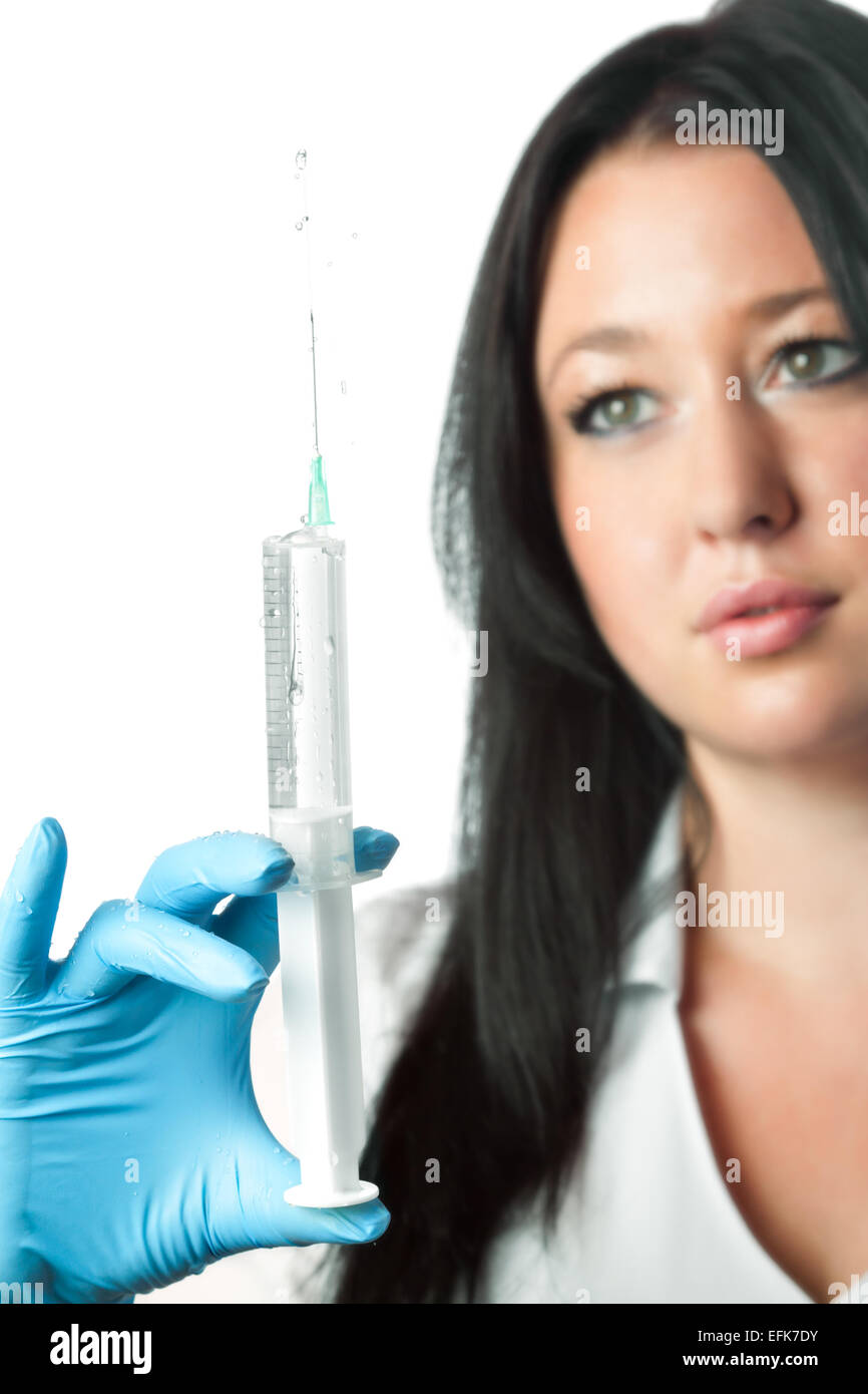 Giovane attraente infermiera tenendo la siringa isolati su sfondo bianco Foto Stock