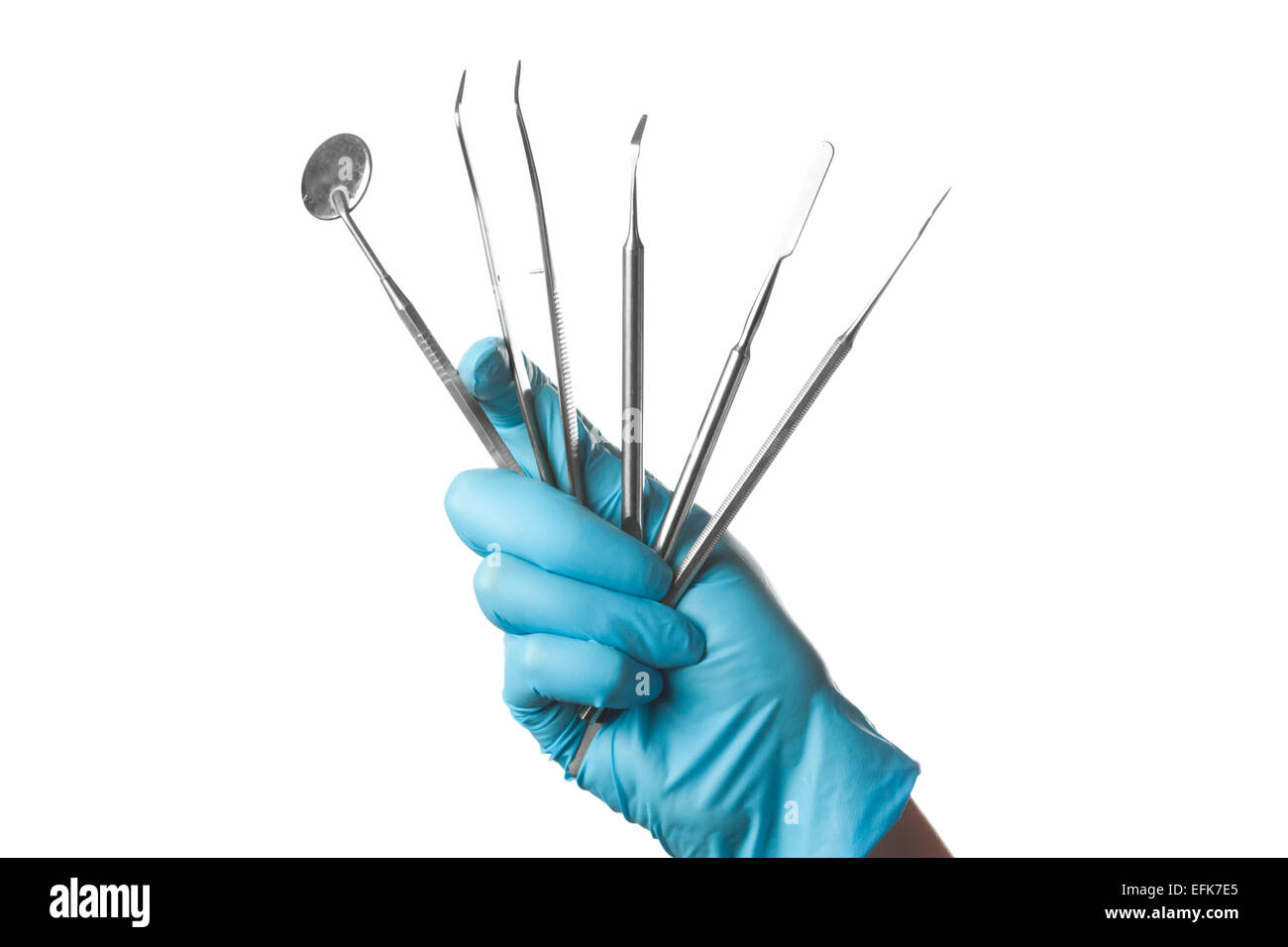 Mano nel guanto blu holding strumenti dentali isolati su sfondo bianco Foto Stock