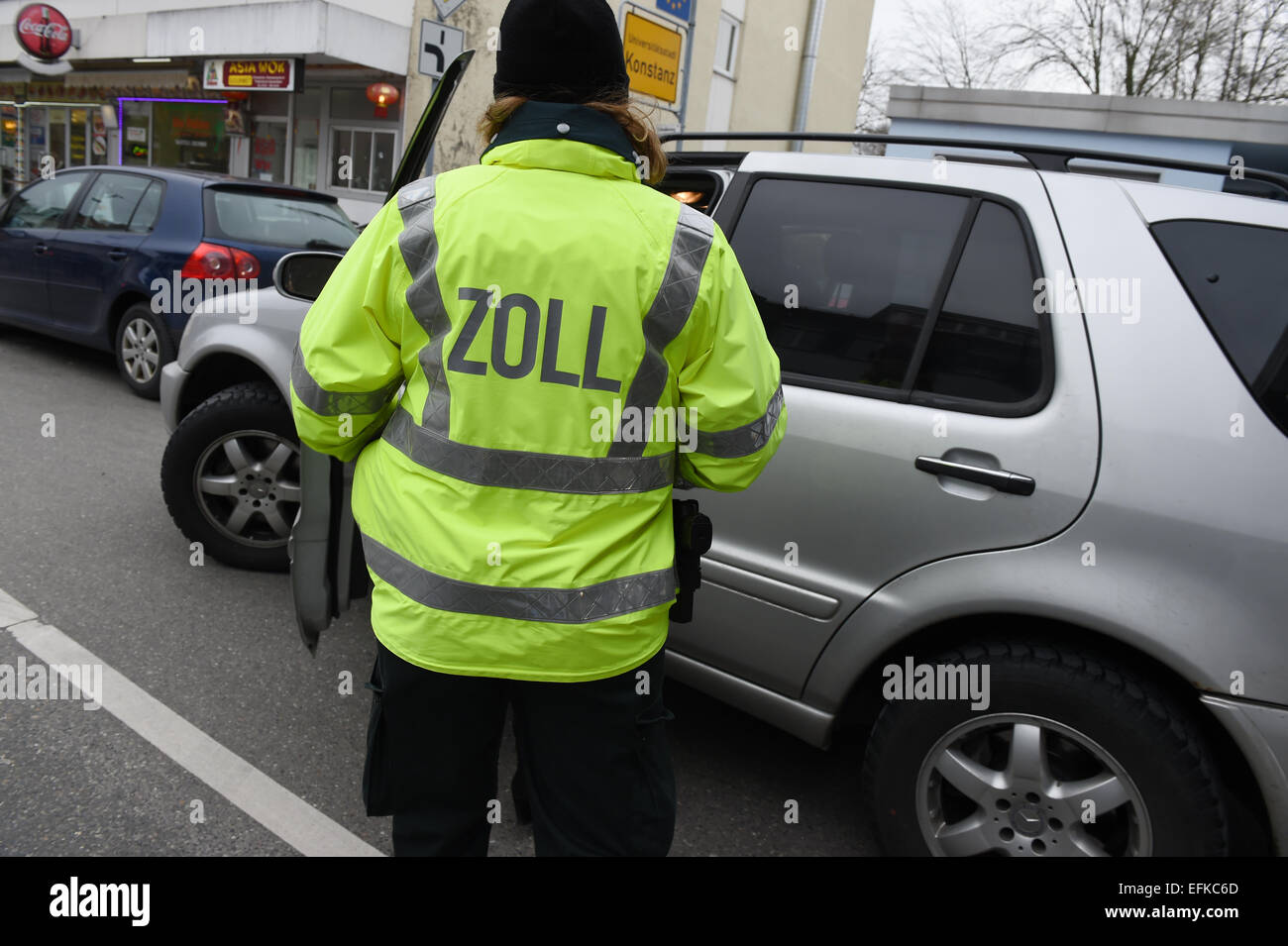 Un funzionario doganale controlla i dati personali di un cittadino svizzero che passa il confine con la Germania a Konstanz, Germania, il 6 febbraio 2015. Foto: FELIX KAESTLE/dpa Foto Stock