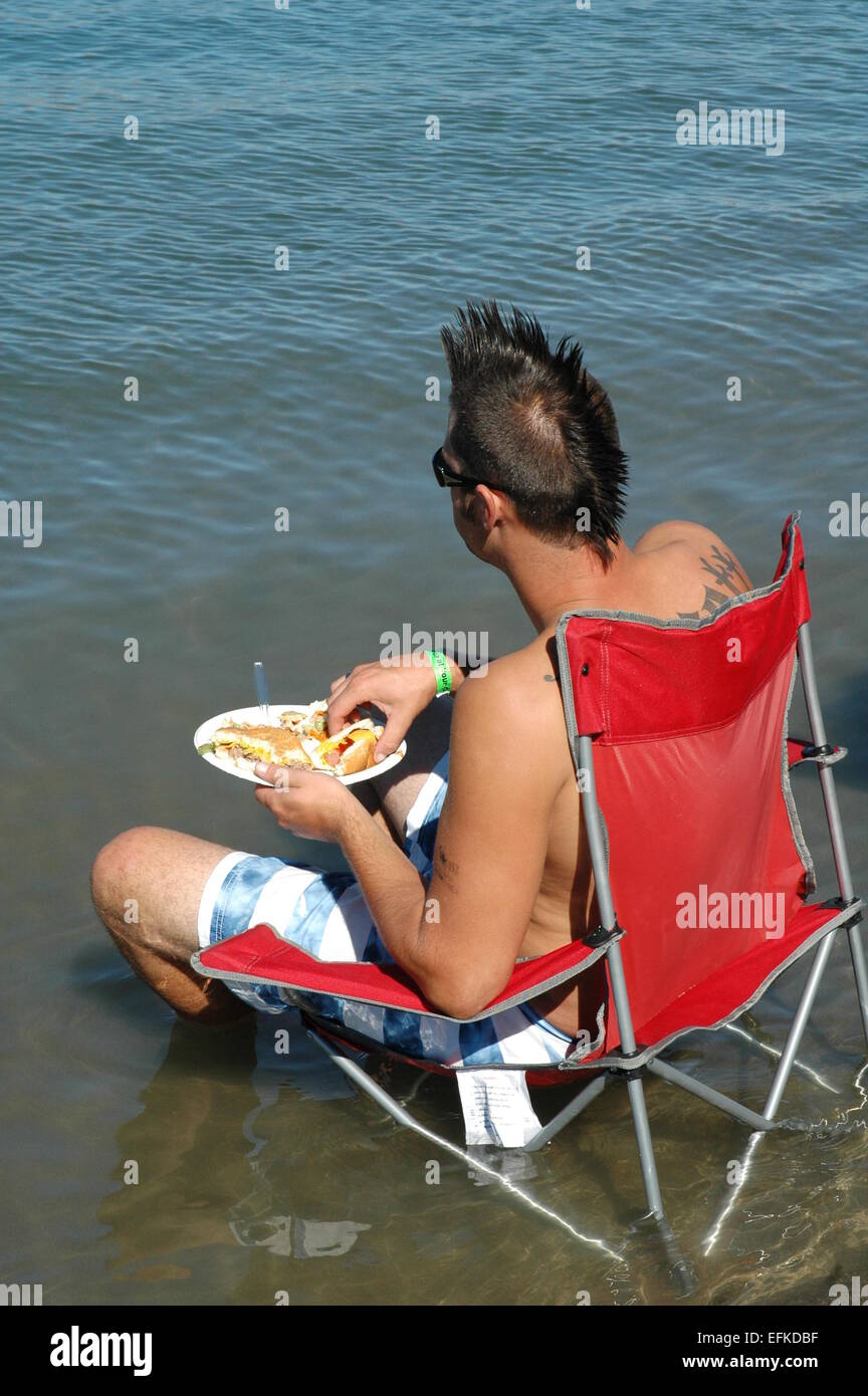 Uomo di mangiare il pranzo al lago. Foto Stock