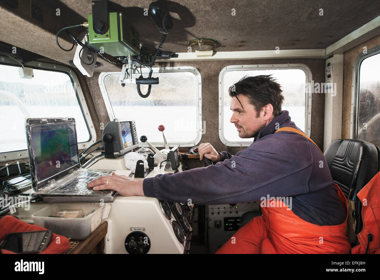 Guida del pescatore barca da pesca con laptop Foto Stock