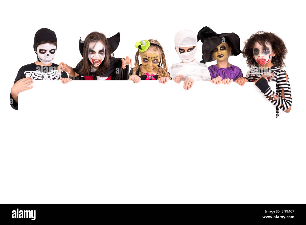 I bambini con la faccia di vernice e di costumi di Halloween su una lavagna bianca Foto Stock