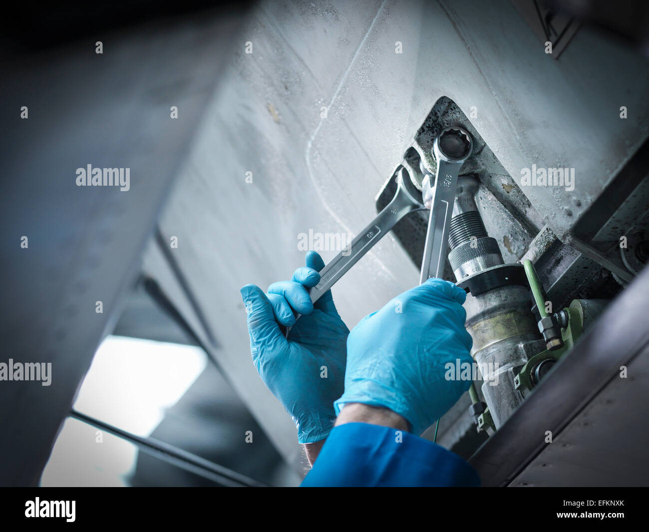 Dettaglio dell'ingegnere utilizzando chiave nella manutenzione aeromobili fabbrica, close up Foto Stock
