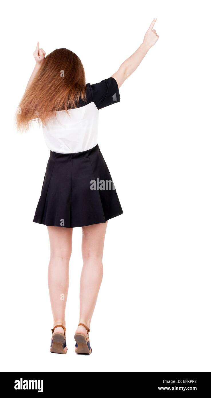 Vista posteriore della donna allegra celebrando la vittoria in alto le mani. Vista posteriore di raccolta persone. vista posteriore di persona. Isolato su sfondo bianco snello redhead in un abito mostra il simbolo di successo o autostop Foto Stock