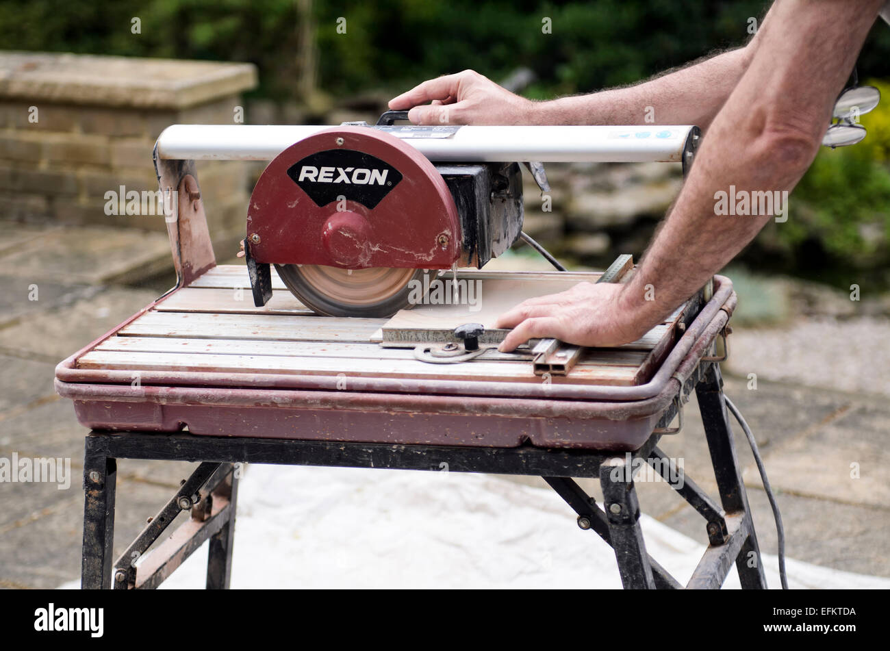 Uomo che utilizza acqua raffreddata piastrella ceramica macchina da taglio release disponibile Foto Stock