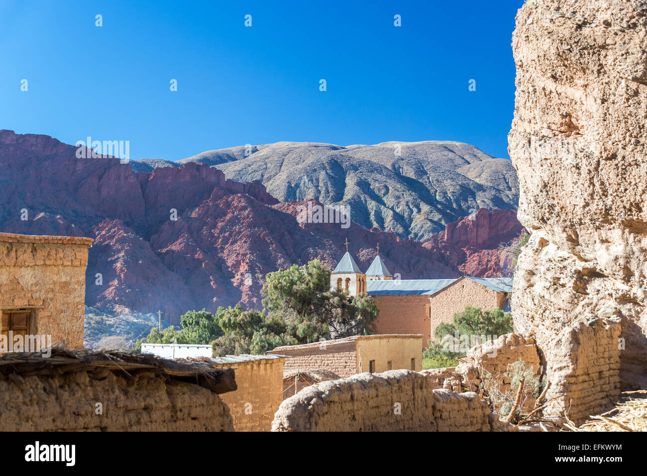 Chiesa insieme contro una drammatica cliff e belle colline rosse nella piccola cittadina di Espicaya vicino a Tupiza, Bolivia Foto Stock