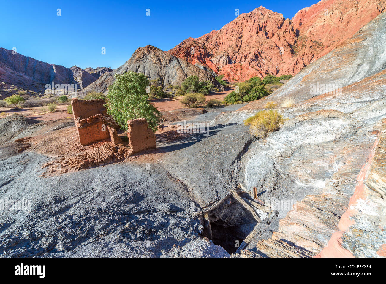 Rovinato adobe edificio accanto un abbandonata miniera di rame con il rosso delle colline sullo sfondo della città Titihoyo vicino a Tupiza, boli Foto Stock