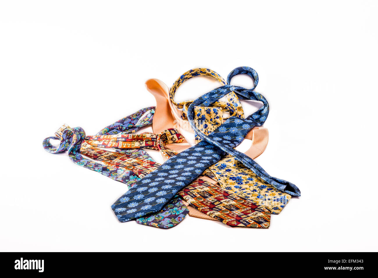 Un cumulo di diversi legami giacente mescolate su un isolato bianco sullo sfondo. Foto Stock