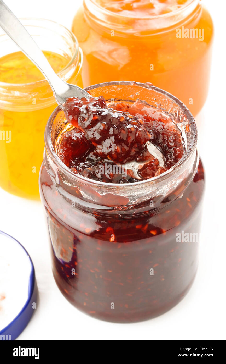 Vasetti di confettura di frutti su sfondo bianco Foto Stock