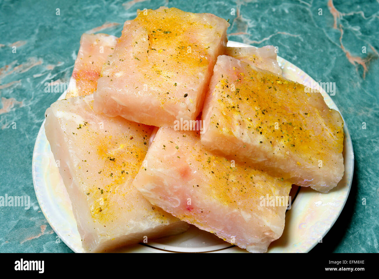 Materie di filetto di pesce su una piastra in panatura Foto Stock