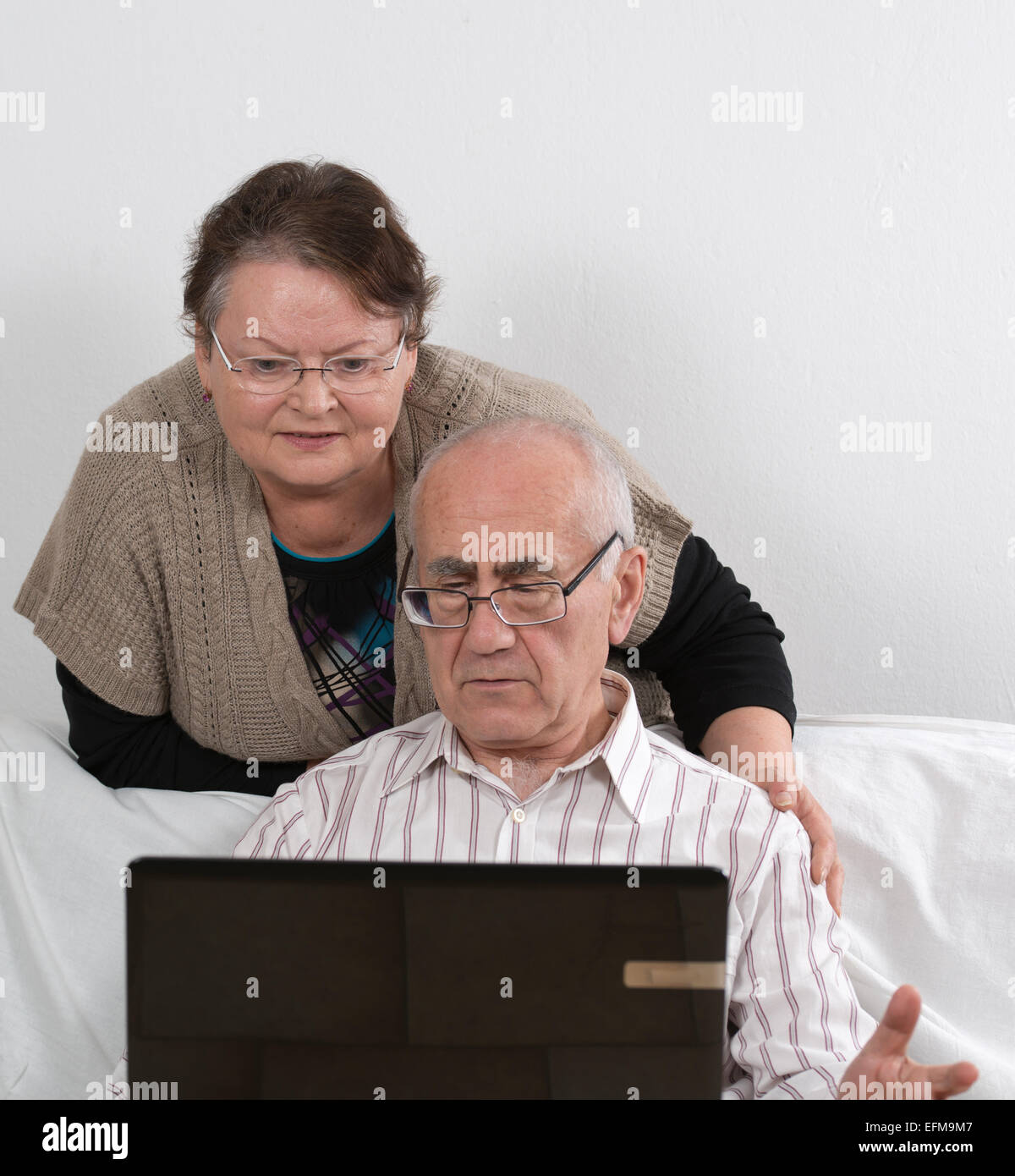 Seniors giovane funziona con computer laptop Foto Stock