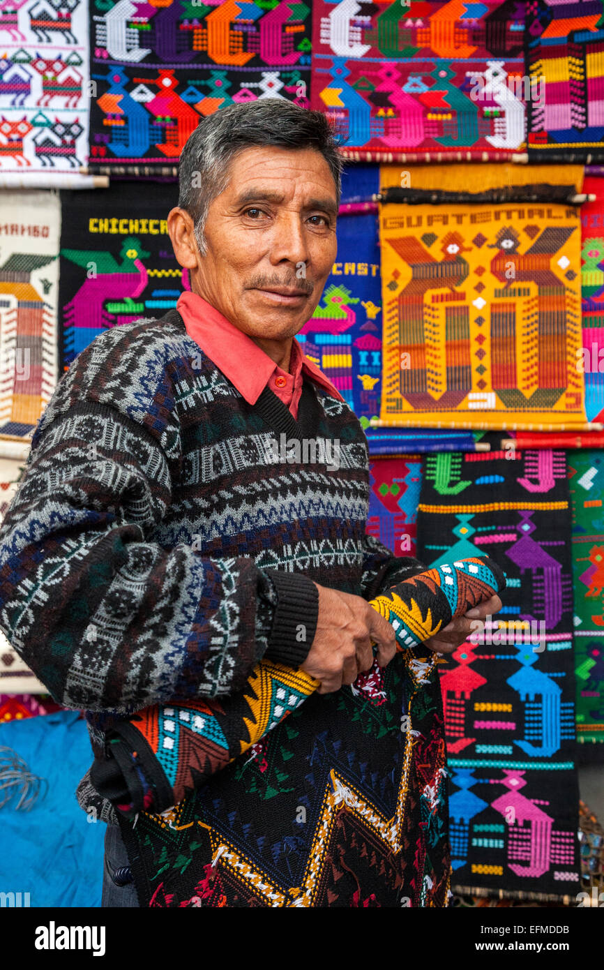 Chichicastenango, Guatemala. Fornitore di tappezzerie e tessuti di Souvenir nel suo negozio. Foto Stock