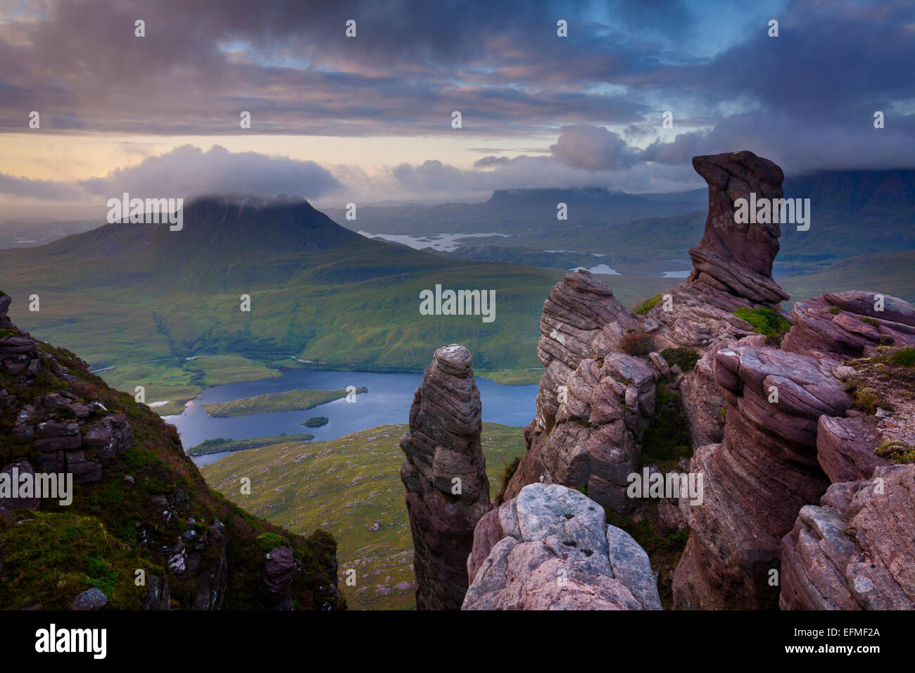 I pinnacoli di arenaria torridoniana su Sgorr Tuath, Coigach, con Stack Pollaidh come sfondo Foto Stock