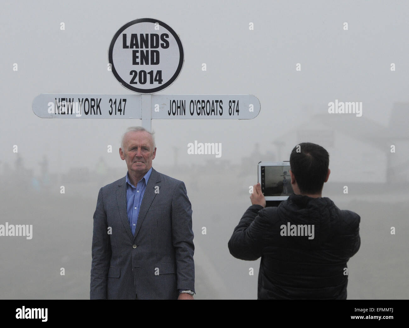 Un turista pone accanto al segno fanmous a terre Ens, Cornwall nella fitta nebbia. Foto Stock