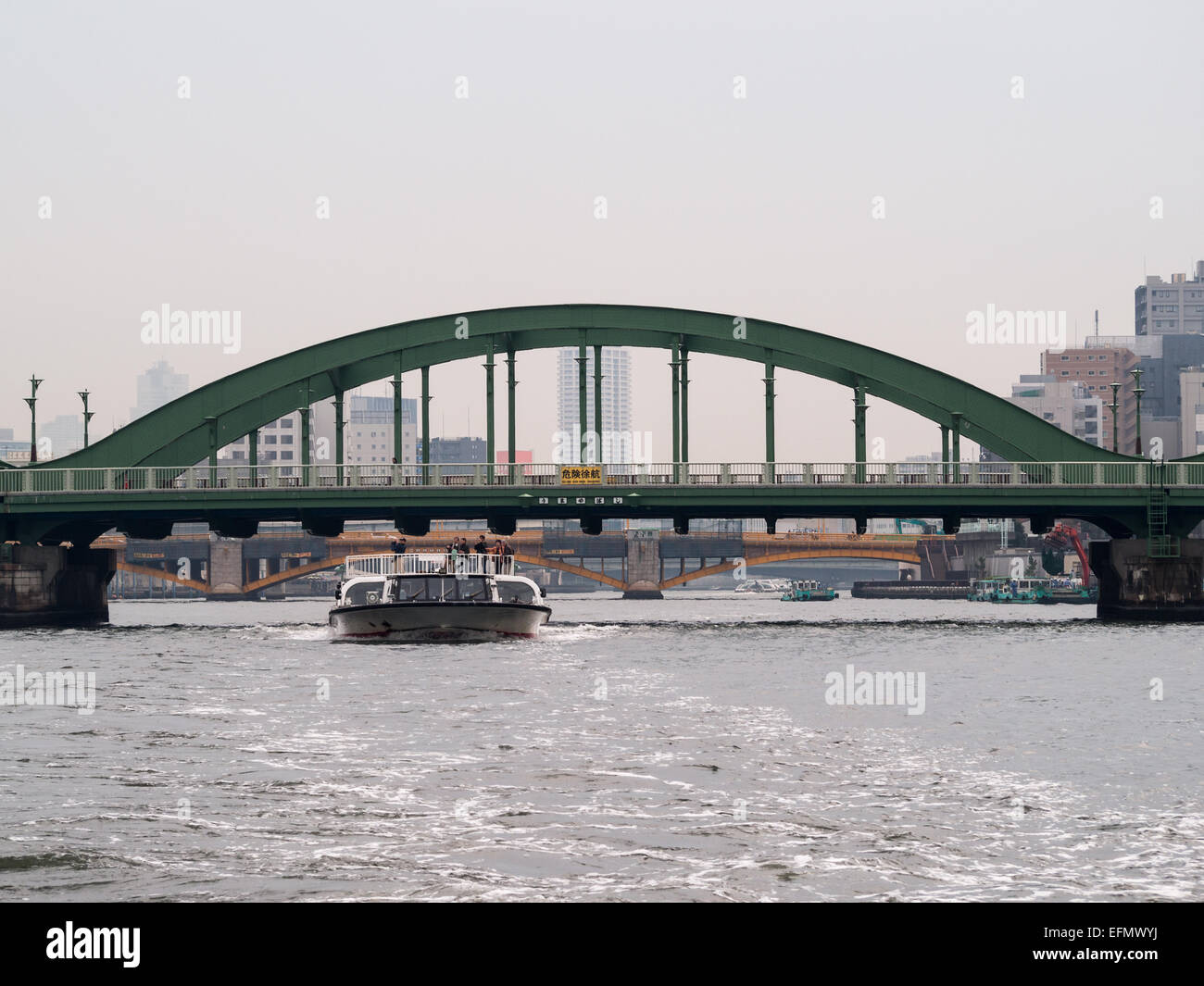 Barca passando sotto un ponte nel fiume Sumida Foto Stock