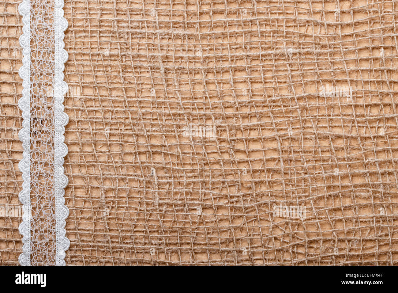 Pizzo Bianco nastro sulla maglia marrone materiale, naturale sfondo di tela Foto Stock