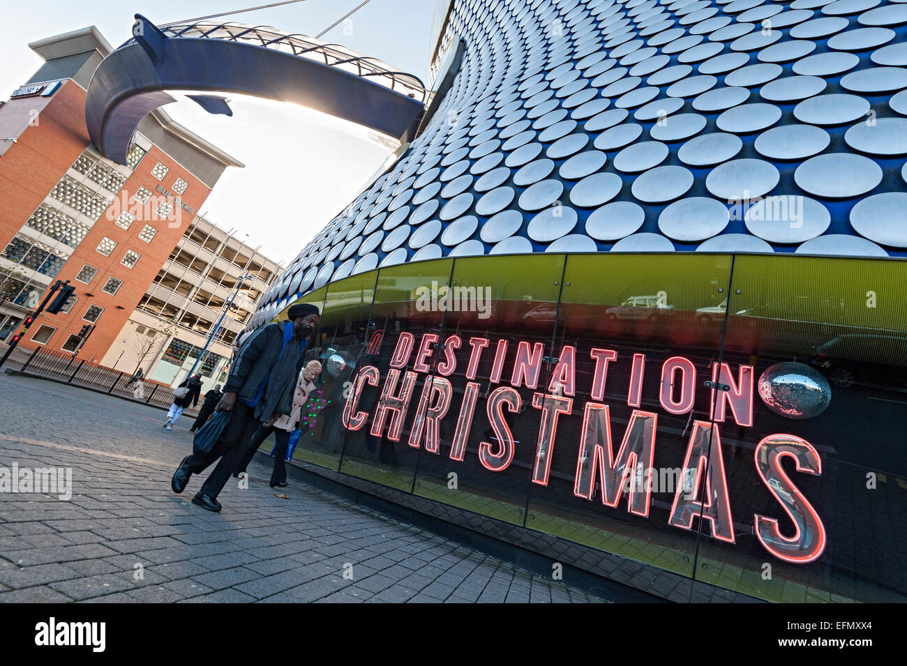 Christmas Shopper Birmingham Selfridges a piedi passato Natale destinazione insegna al neon Foto Stock