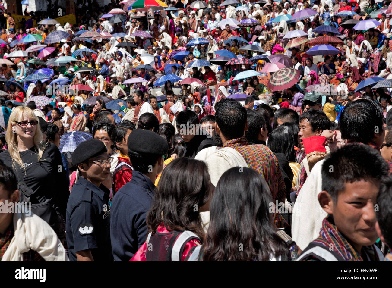 Il Bhutan - bhutanesi in abiti tradizionali e i turisti riempiono il Trashi Chhoe Dzong per un giorno di cerimoniale di danza e musica. Foto Stock