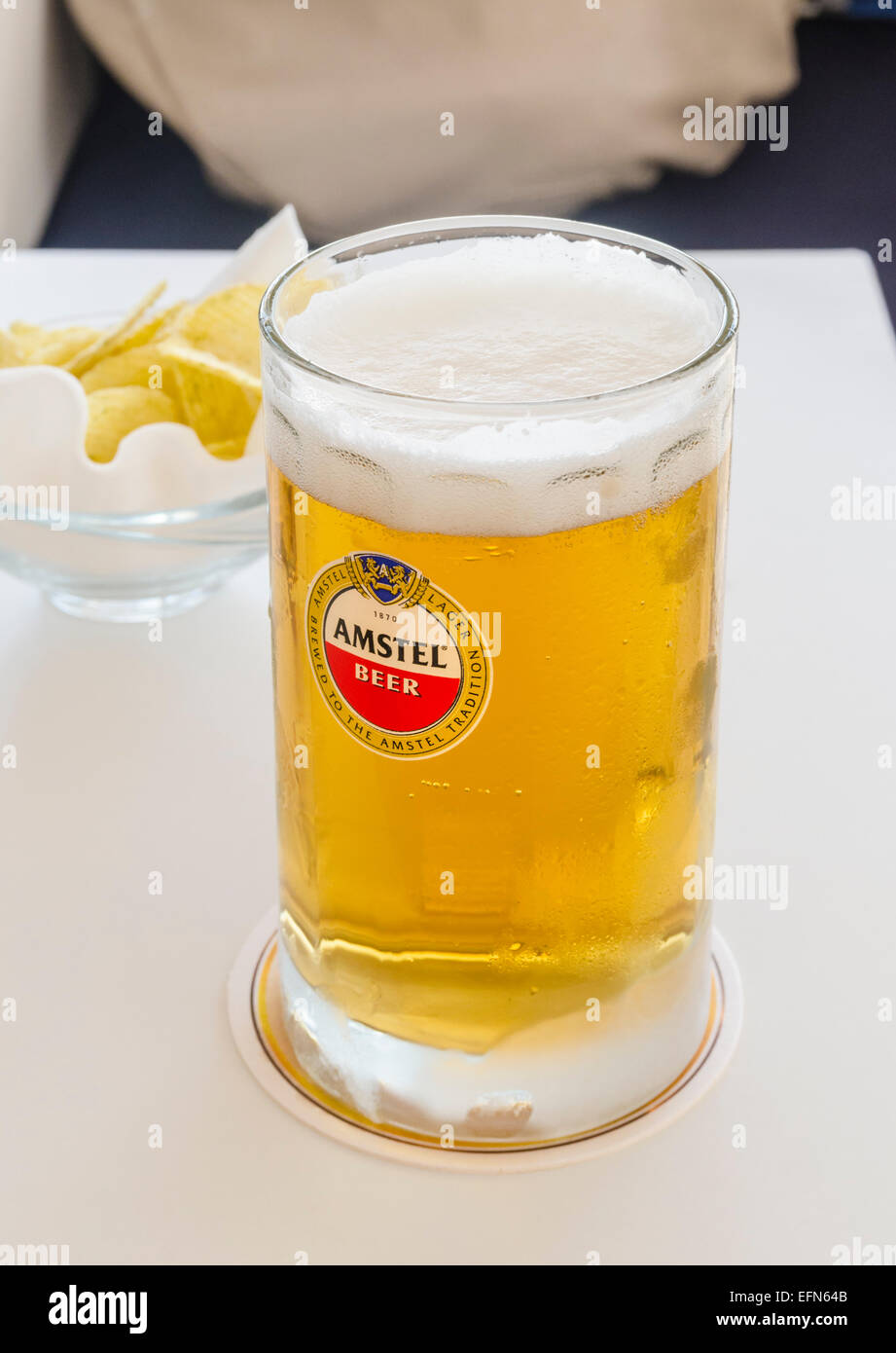 Amstel boccale di birra e patatine snack su un tavolo Foto Stock