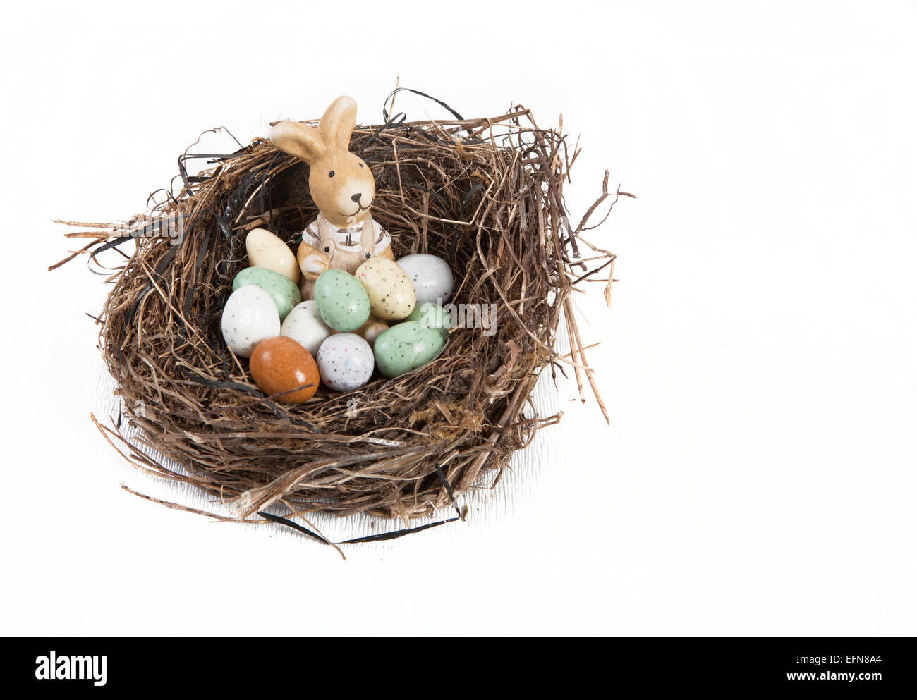 Nido di Pasqua decorate con le uova e il coniglio di fronte a uno sfondo bianco Foto Stock