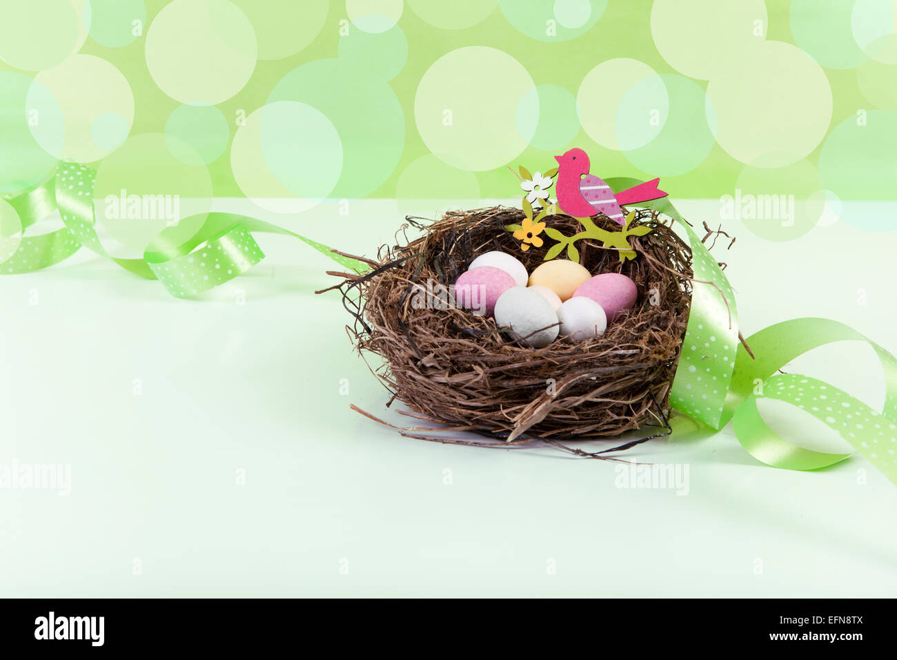 Nido di Pasqua decorate con uova contro lo sfondo di colore verde Foto Stock