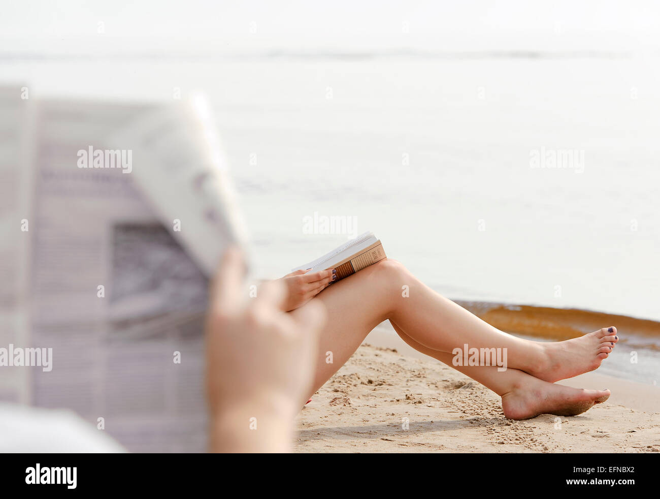 Donna i piedi nella sabbia sulla spiaggia Foto Stock