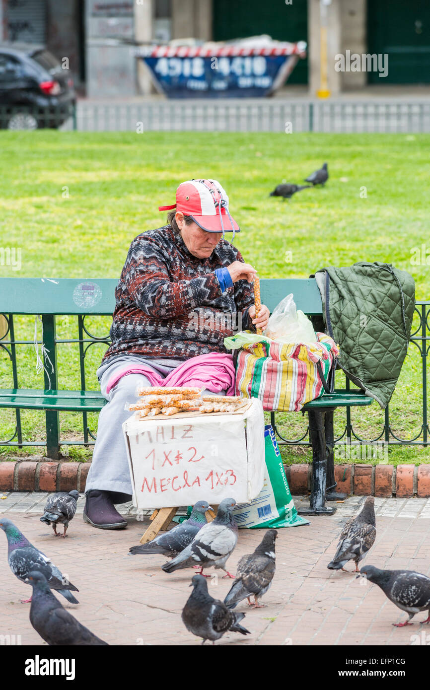 Povero vecchio donna vendita di arachidi per alimentare i piccioni in Plaza de Mayo, il centro di Buenos Aires, Argentina, di soggiorno living lifestyle Foto Stock