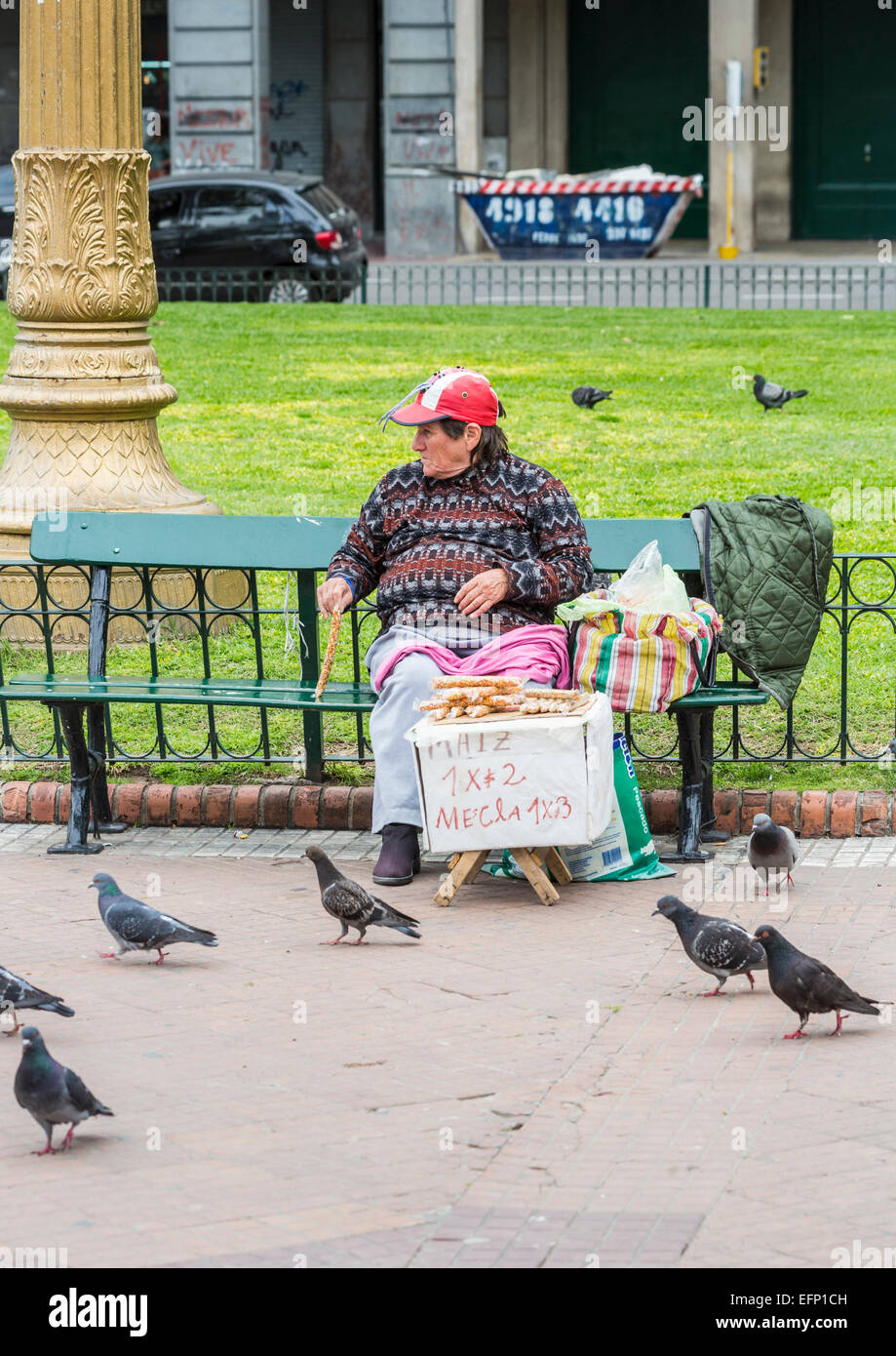 Povero vecchio donna vendita di arachidi per alimentare i piccioni in Plaza de Mayo, il centro di Buenos Aires, Argentina, di soggiorno living lifestyle Foto Stock