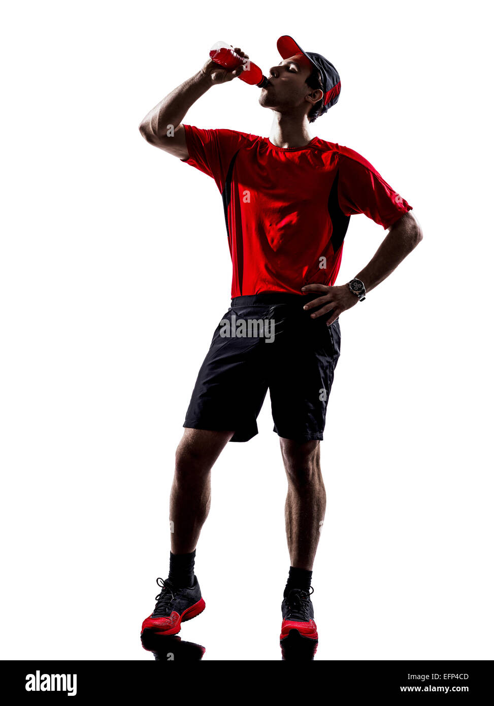 Un giovane uomo corridori atleti di bere bevande energetiche in silhouette isolati su sfondo bianco Foto Stock