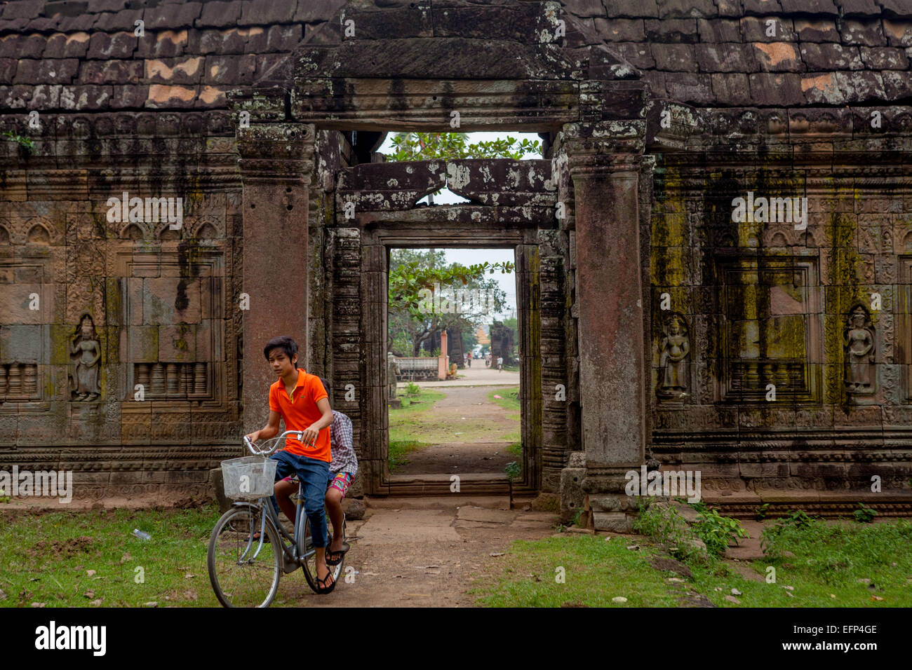 Adolescenti in bicicletta nel cortile posteriore del tempio di Banteay Prey Nokor a Kampong Cham, Cambogia. Foto Stock